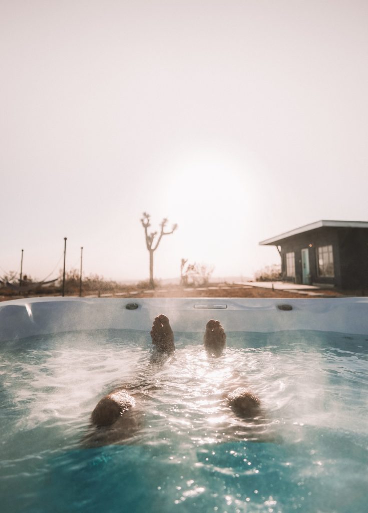 Man enjoying a relaxing soak in a hot tub that has been cleaned using proper hot tub chemicals.