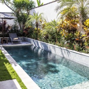20-a-lush-tropical-garden-a-couple-of-loungers-and-a-small-and-narrow-pool-clad-with-mosaic-ti...jpg