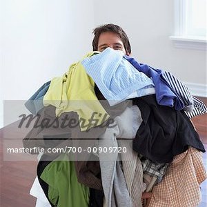 700-00909720em-man-carrying-pile-of-laundry-stock-photo.jpg