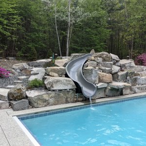 Philpott pool with slide in a stone berm