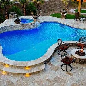 freeform-pool-with-raised-spa-with-spillover-travertine-decking-with-lighted-steps-and-fire-pit.jpg